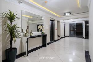 a hallway with a mirror and a potted plant at Aptos a 2min da praia Balneário Camboriú/SC - EAC in Balneário Camboriú