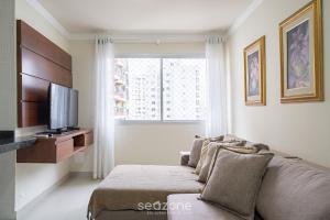 a living room with a couch and a television at Aptos a 2min da praia Balneário Camboriú/SC - EAC in Balneário Camboriú