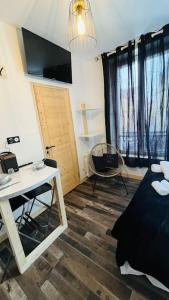 a bedroom with a bed and a table and a desk at Studio Woody entre Disney et Paris in Lagny