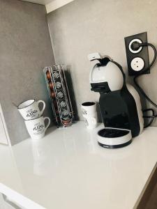 a coffee maker and coffee cups on a counter at Studio Woody entre Disney et Paris in Lagny +14 photos