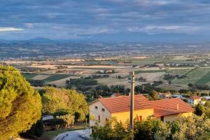a yellow house with a red roof in a village at A casa di Vittorio - tra mare e colline in Montecosaro
