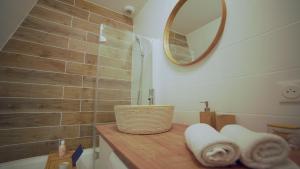 a bathroom with a sink and a mirror and towels at Pyrénées Addict, appartement full equipped in Orthez