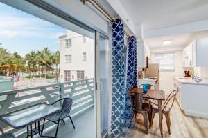 Un balcón con mesa y sillas y una cocina. en Balcony Deco Apt, w/2 QueenBeds, on Ocean Dr Beach, en Miami Beach