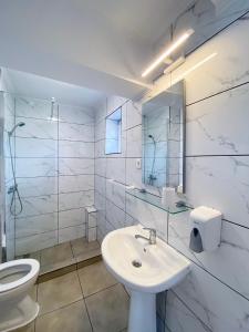 a white bathroom with a sink and a toilet at Relax by the Sea Rooms next to Nibiru in Costinesti +20 photos
