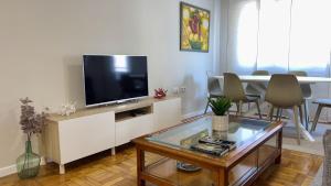 Una sala de estar con un televisor y una mesa. en Vetusta Nest, en Oviedo 30 fotos más