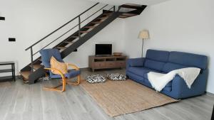 a living room with a blue couch and a staircase at Val de ver in Pol