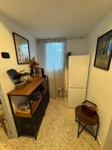 Il comprend une cuisine équipée d'un réfrigérateur, d'une table et d'une chaise. dans l'établissement PrincipeAmedeo apartment 89 steps to the terrace, à Bari