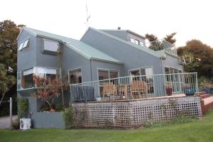 a house with a large deck with chairs on it at Tui Hideaway in Invercargill