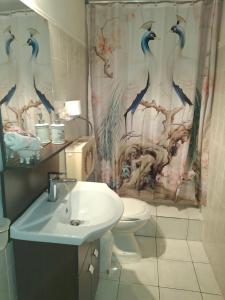 a bathroom with a toilet and a shower curtain at Eretria houses in Eretria