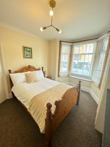 a bedroom with a large bed in a room with windows at Shine Lodge in Kent