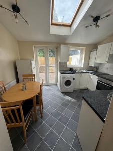 a kitchen with a table and a dining room at Shine Lodge in Kent