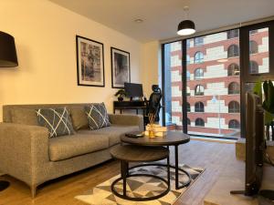 a living room with a couch and a table at Cozy City Centre Apartment with Free Gym and Free Coffee in Birmingham