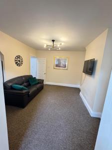 a living room with a couch and a television at Shine Lodge in Kent
