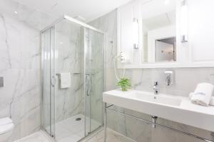 a bathroom with a glass shower and a sink at Ambria Apartments Promenada in Świnoujście +71 photos