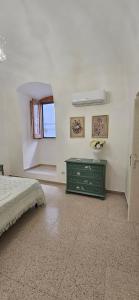 a bedroom with a green dresser and a window at Il vicoletto in Canosa di Puglia +14 photos