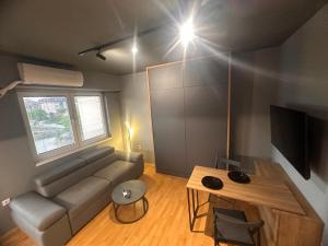 a living room with a couch and a tv and a table at Ambe Apartments in Bitola