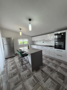 a kitchen with white cabinets and a table and chairs at Apartment Donata in Privlaka