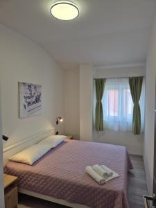 a bedroom with a bed with two towels on it at Apartment Donata in Privlaka