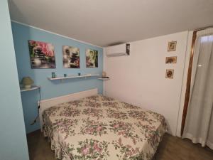 a bedroom with a bed with a floral bedspread at L06 - Trilocale a 300 mt dal mare in Ancona