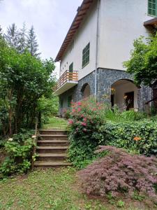 a building with stairs and flowers in front of it at La casa di nonna Angela in Sassello