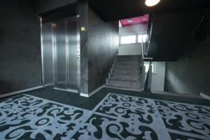 a lobby with a staircase and a elevator with a glass door at Hotel Swiss Bellevue in Kreuzlingen