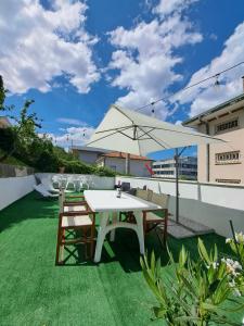 a patio with a white table and chairs and an umbrella at Appartamento estivo PONENTE - Misano Adriatico -RN- in Misano Adriatico