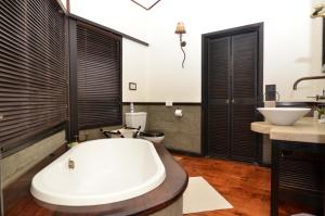 a bathroom with a bath tub and a sink at Umthiba Bush Lodge in KwaNibela +39 photos