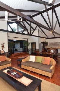 a living room with two couches and a table at Umthiba Bush Lodge in KwaNibela