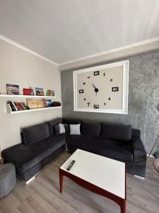 a living room with a black couch and a clock at Golem in Golem
