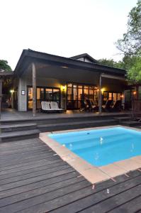a swimming pool in front of a house at Umthiba Bush Lodge in KwaNibela