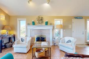 a living room with two chairs and a fireplace at Firepit Lagoon in Oceanside