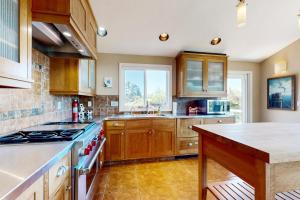 a kitchen with wooden cabinets and a stove top oven at Firepit Lagoon in Oceanside +17 photos