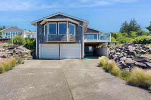 a house with a garage and some rocks at Firepit Lagoon in Oceanside