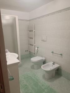 a white bathroom with a toilet and a bidet at La Sirenetta in Tortoreto Lido