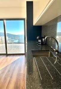 a kitchen with a sink and a window with a view at Encosta do Gerês Village in Ventosa