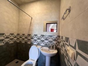 a bathroom with a toilet and a sink at Green Garden Hotel in Makhinjauri