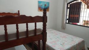 ein Schlafzimmer mit einem Bett und einem Fenster in der Unterkunft Casa na Martim de Sá in Caraguatatuba + 24 Fotos