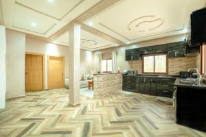 a large kitchen with wooden floors and black cabinets at Blumen Villa in Marrakesh