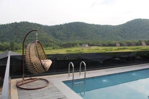 a chair sitting on a balcony next to a swimming pool at Villa Bella Vue in Gabala