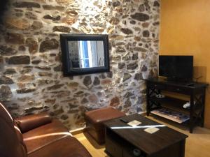 a living room with a tv on a stone wall at SUN SETE Loft in Sète
