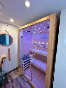 a walk in shower with a tub in a room at Maison Campagne SPA, Sauna, cinéma, jardin in Valuéjols