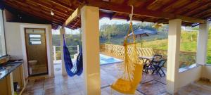 une terrasse couverte avec des hamacs et une terrasse avec une table dans l'établissement Chácara paraíso, à Socorro