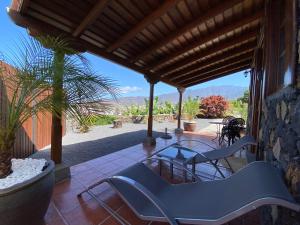 een patio met blauwe stoelen en een glazen tafel bij Casa El Morro in Los Llanos de Aridane