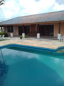 a large swimming pool in front of a house at Recanto Praia Peruibe in Peruíbe