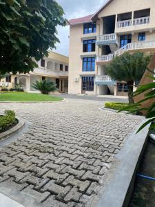 a cobblestone street in front of a building at Hotel new plazza in Kisangani