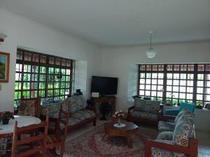 ペルイベにあるRecanto Praia Peruibeのリビングルーム(ソファ、テレビ、窓付)