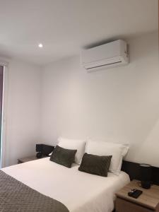 a bedroom with a white bed with two pillows at Cosy T3, proche centre ville in Aix-en-Provence