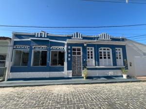 a blue house on a cobblestone street at Casarao da Terra in Prado