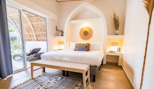 a bedroom with a white bed and a table at Les Voiles Blanches - Luxury Lodge in Tamarindo