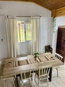 a wooden table in a room with chairs and a window at Cabañas CheRu 5 in Posadas